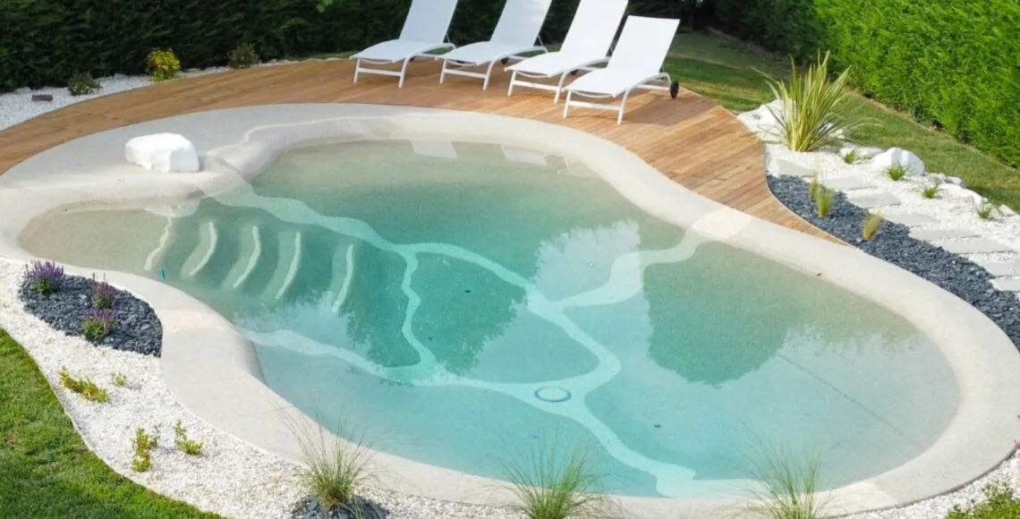 Beach pool with a sandy walk-in entry and sun loungers